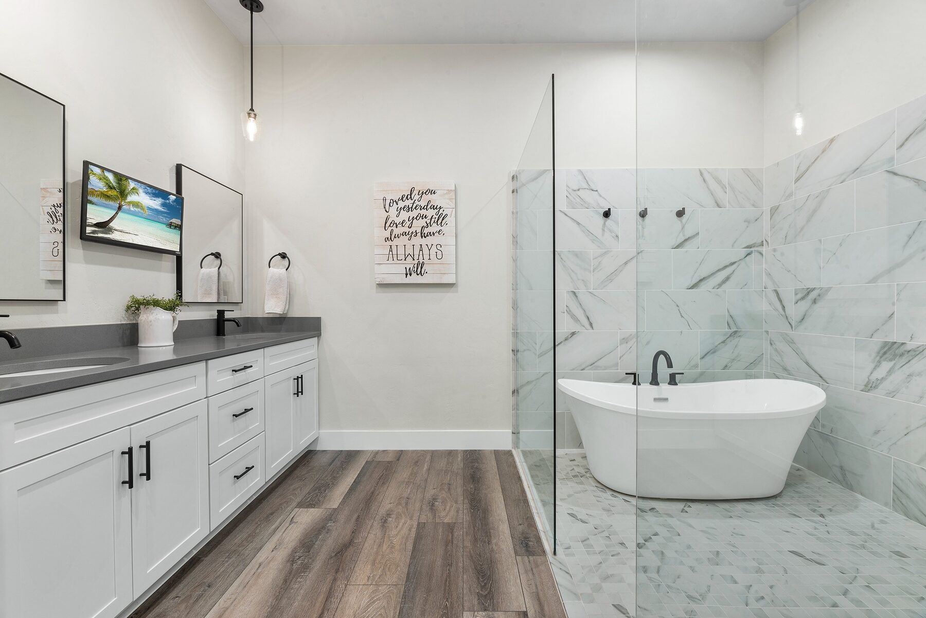 Renovated bathroom with white cabinetry and freestanding tub